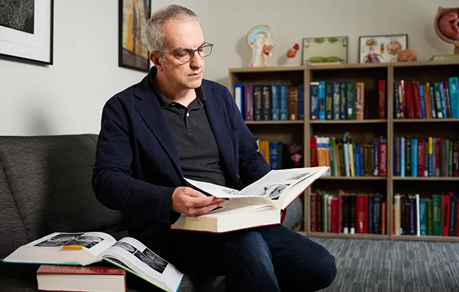 Man reading large book in office library